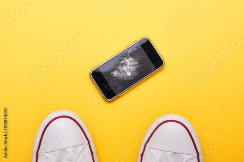 Mobile phone with broken screen on floor
