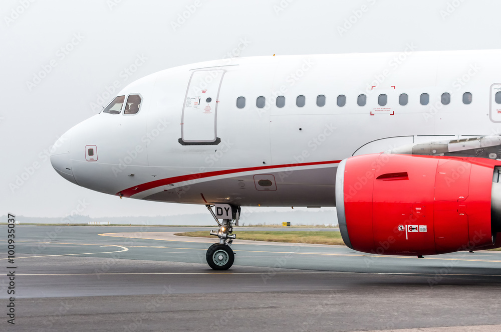 White-red airplane taxiing in an airport