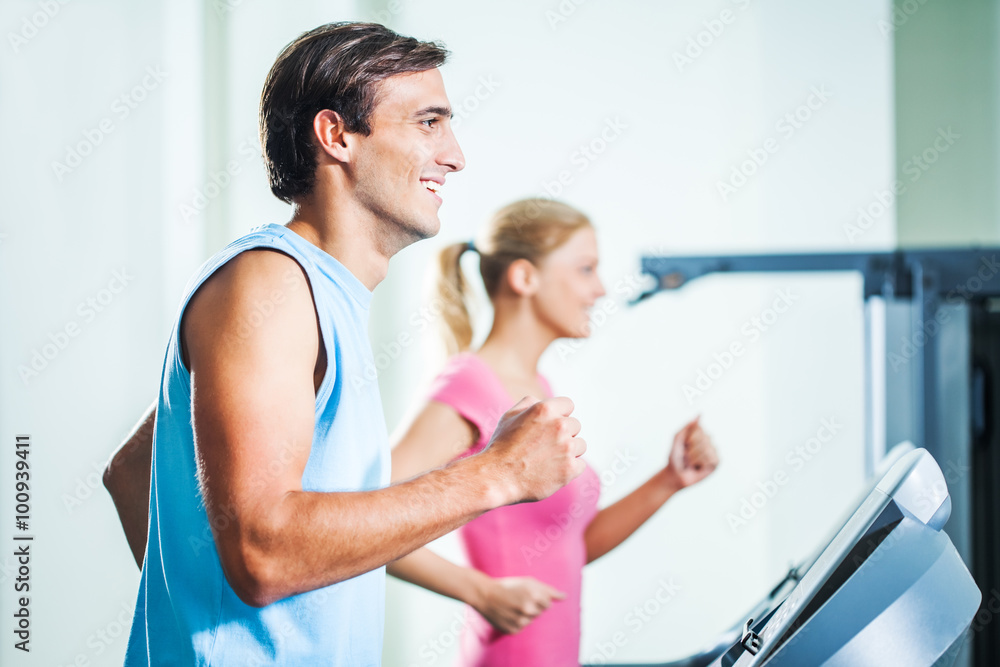 Happy couple exercising in gym Happy couple exercising in gym