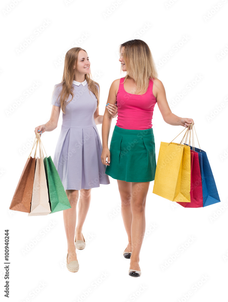 front view of two girls walking with shopping bags. Isolated ov front view of two girls walking with shopping bags. Isolated ov