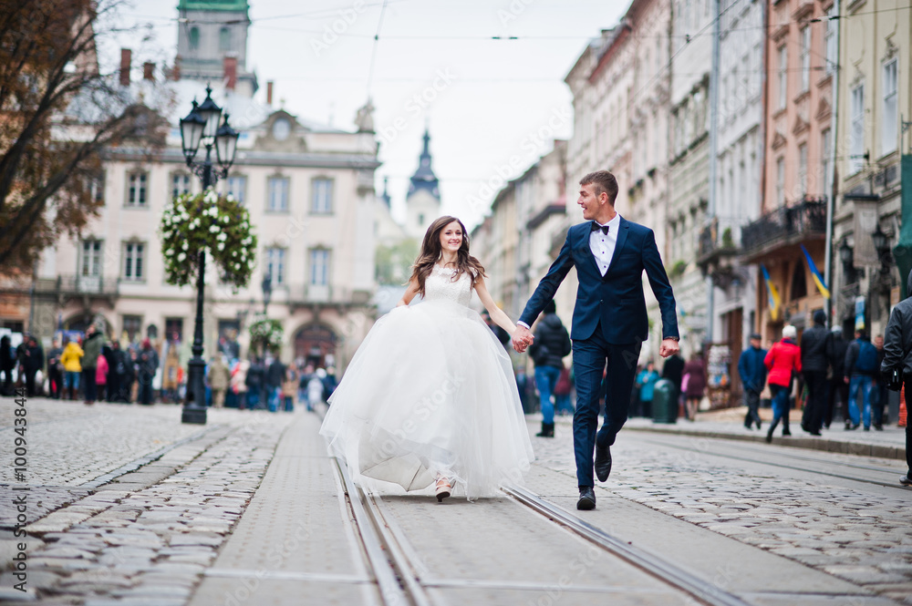Wedding couple walking on tram ways