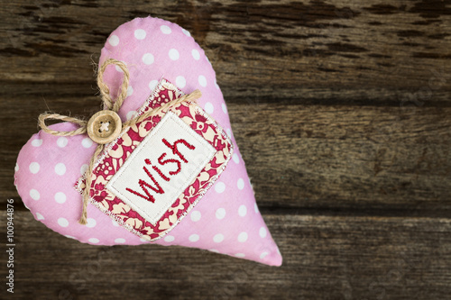 .Pink soft handmade fabric textile heart with word WISH on woode