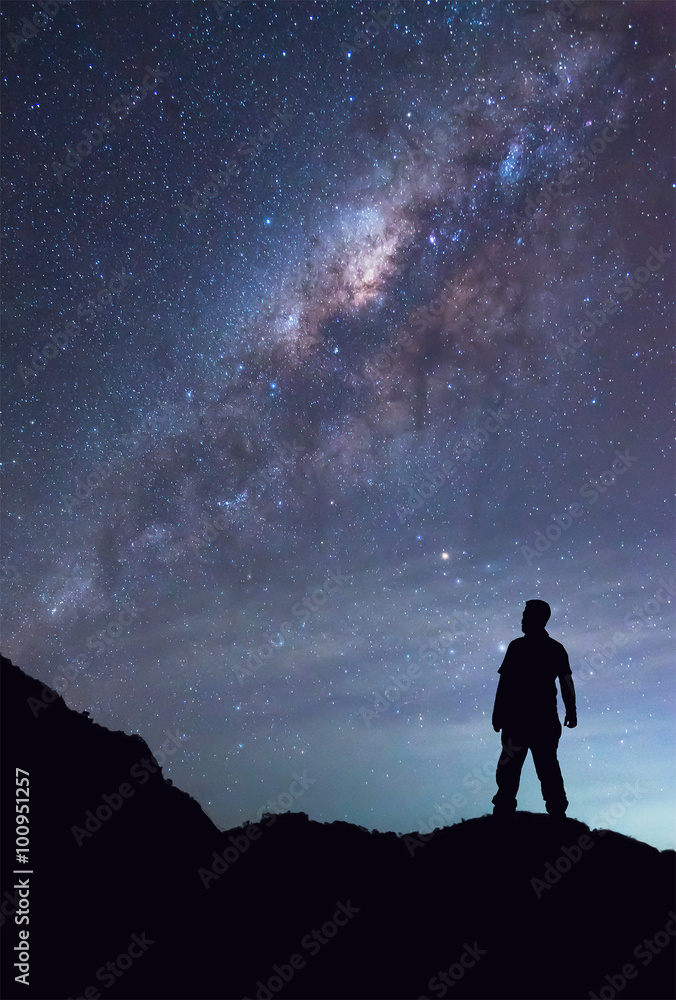 A person is standing and seeing Milky Way galaxy on night sky. A person is standing and seeing Milky Way galaxy on night sky.
