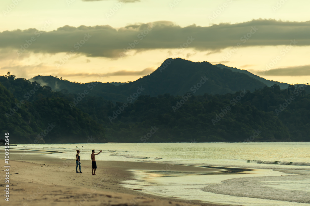 Man and Woman are overlooking the shores of the ocean.