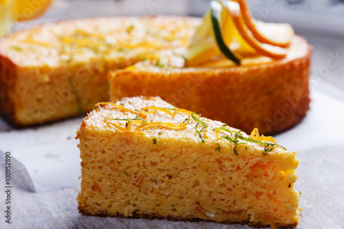 Home made whole testy orange cake on a wooden surface