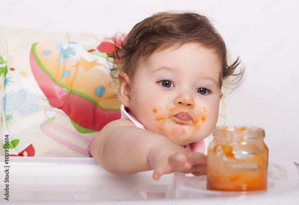 Adorable smudgy baby trying to catch favorite baby food in jar Adorable smudgy baby trying to catch favorite baby food in jar