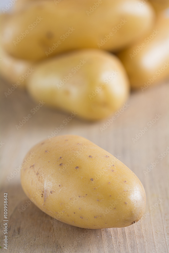 Rohe Kartoffeln liegen auf einem Holzbrett Rohe Kartoffeln liegen auf einem Holzbrett