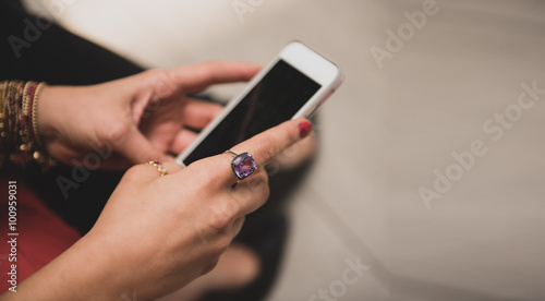 Fototapeta Naklejka Na Ścianę i Meble -  Hands of a woman texting on her mobile phone