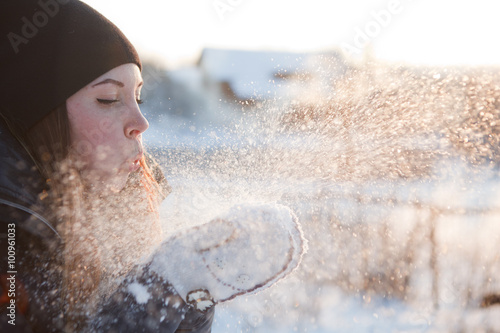 girl blowing on snow