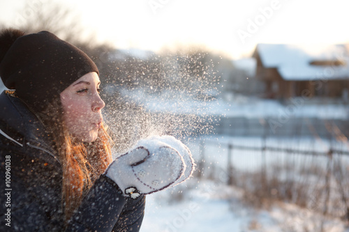 girl blowing on snow