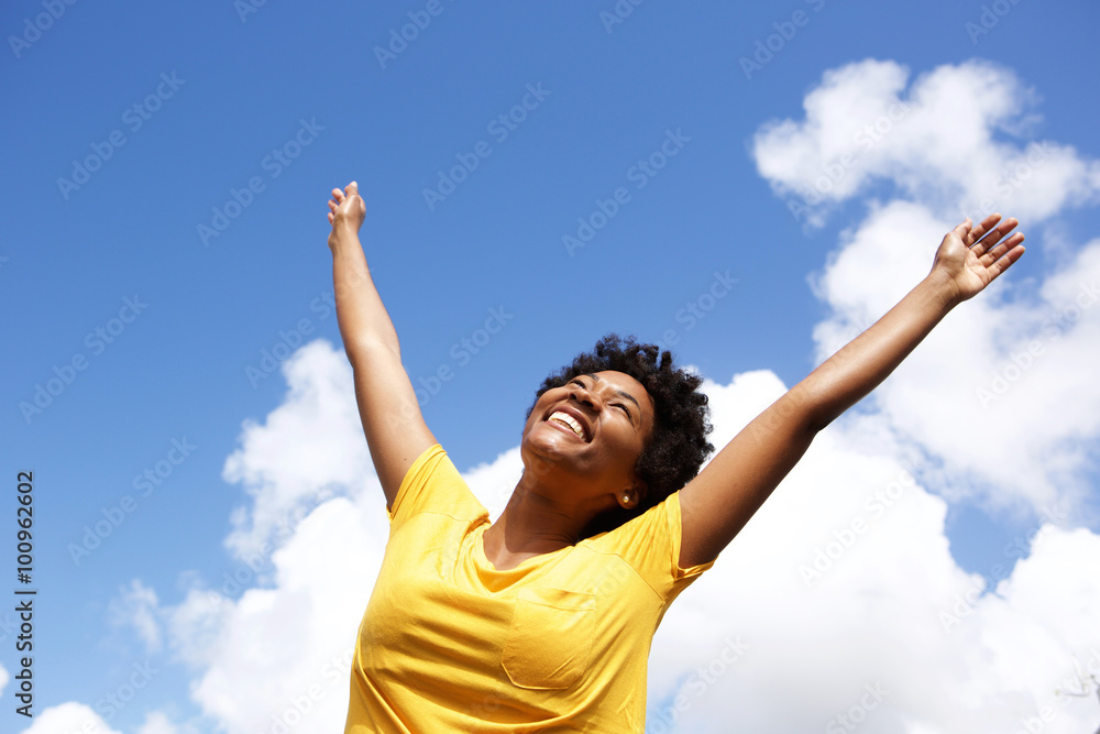Cheerful young woman with hands raised towards sky Cheerful young woman with hands raised towards sky