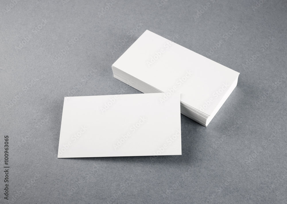 Photo of blank business cards with soft shadows on gray background. Mock-up for branding identity. Studio shot. Photo of blank business cards with soft shadows on gray background. Mock-up for branding identity. Studio shot.