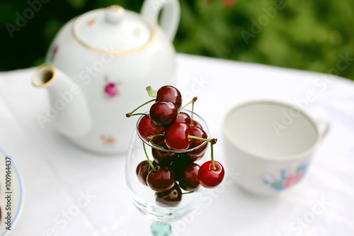 summer background cherry in a glass on a table in the garden  rustic style