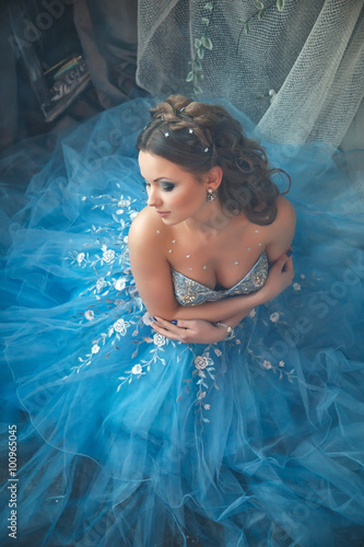 Valokuvatapetti Beautiful young woman in gorgeous blue long dress like Cinderella with perfect m