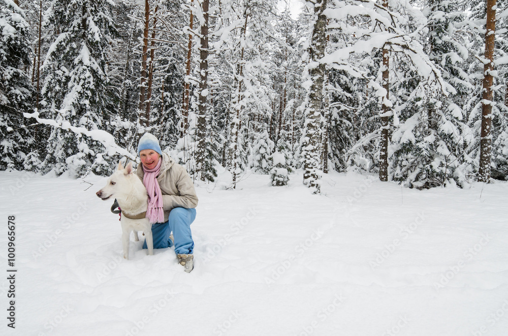 The woman with a dog on walk in a winter wood