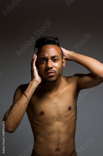 Latin man posing indoor over a grey wall.