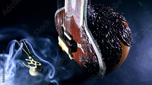 Sitar, a String Traditional Indian Musical Instrument, close-up, blue lens effect. dark background with incense smoke. Evening of ethnic oriental music. Indian Raga photo