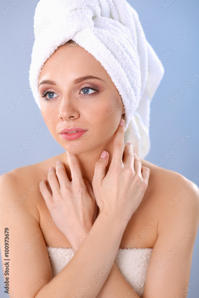 Beautiful woman with a towel on her head on a gray background