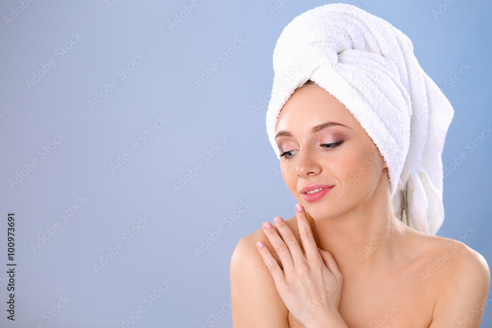 Beautiful woman with a towel on her head on a gray background Beautiful woman with a towel on her head on a gray background
