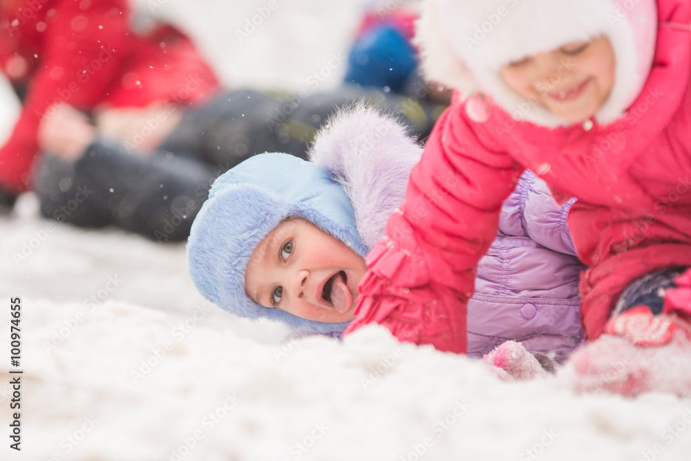 Girl showing tongue rolled down a hill and fell into the snow Girl showing tongue rolled down a hill and fell into the snow