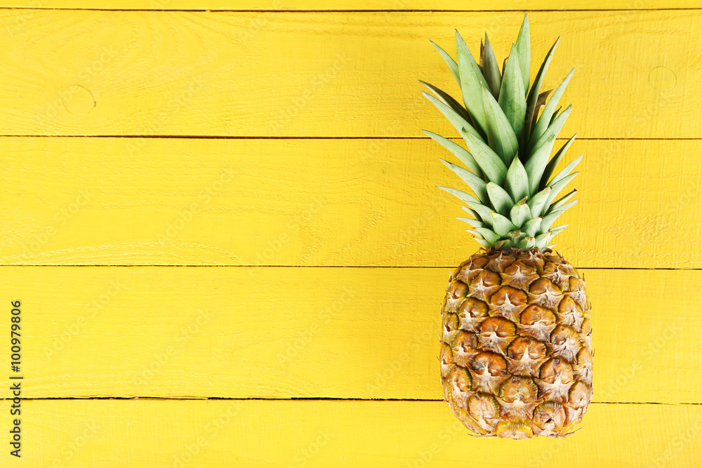 Ripe pineapple on a yellow wooden background - obrazy, fototapety, plakaty 