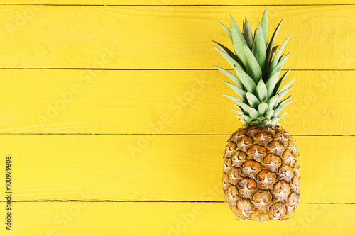 Ripe pineapple on a yellow wooden background Fototapet