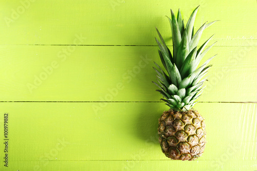 Ripe pineapple on a green wooden background