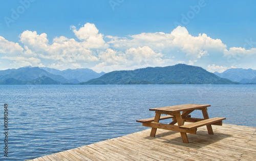 wooden table with benches on platform at sea