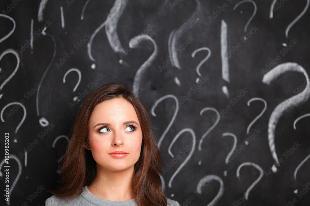 Young girl with question mark on a gray background Young girl with question mark on a gray background