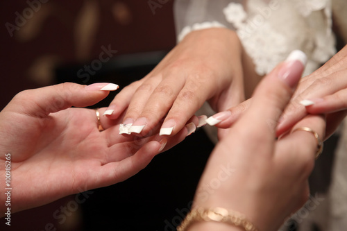 bridesmaid looks at the manicure of the bride