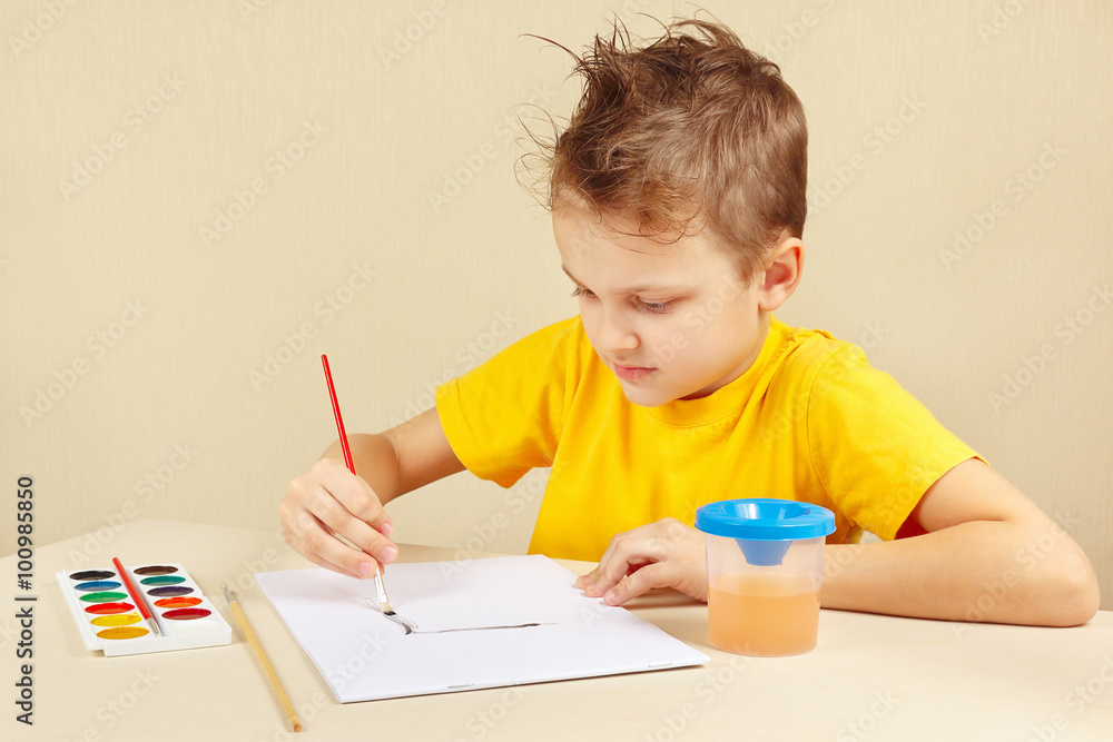 Little boy in a yellow shirt painting colors Little boy in a yellow shirt painting colors