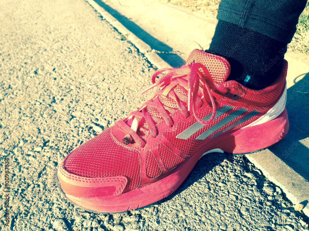 Naklejka premium cigarette end in her running shoes