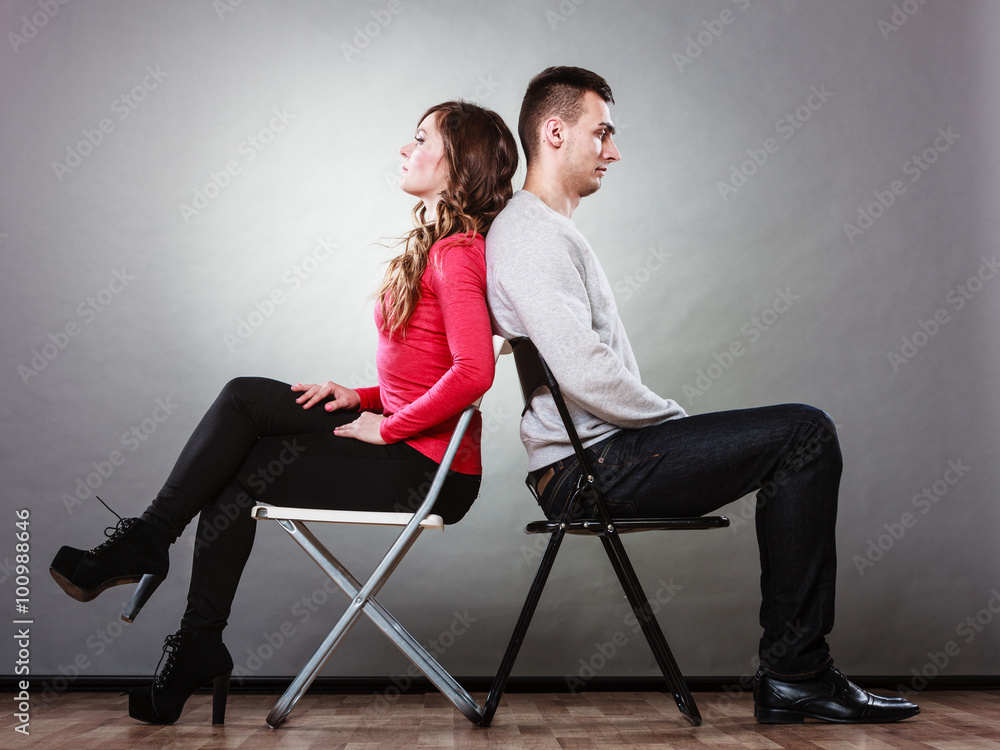 Young couple after quarrel sitting back to back Young couple after quarrel sitting back to back