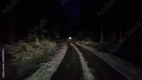 By passing a car in a winter forrest at a dark night, in Raasepori, Uusimaa, Finland
