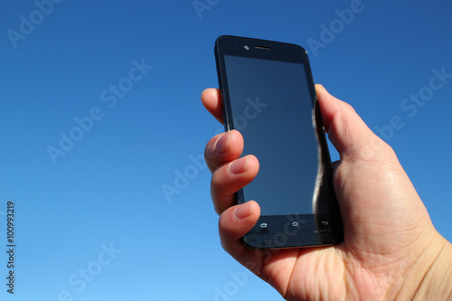 black smart phone and the hand in the blue sky #2