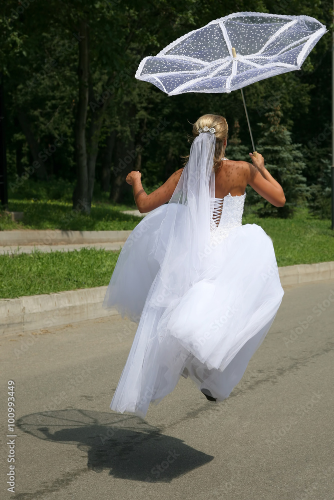 the bride jumps holding a sun umbrella the bride jumps holding a sun umbrella