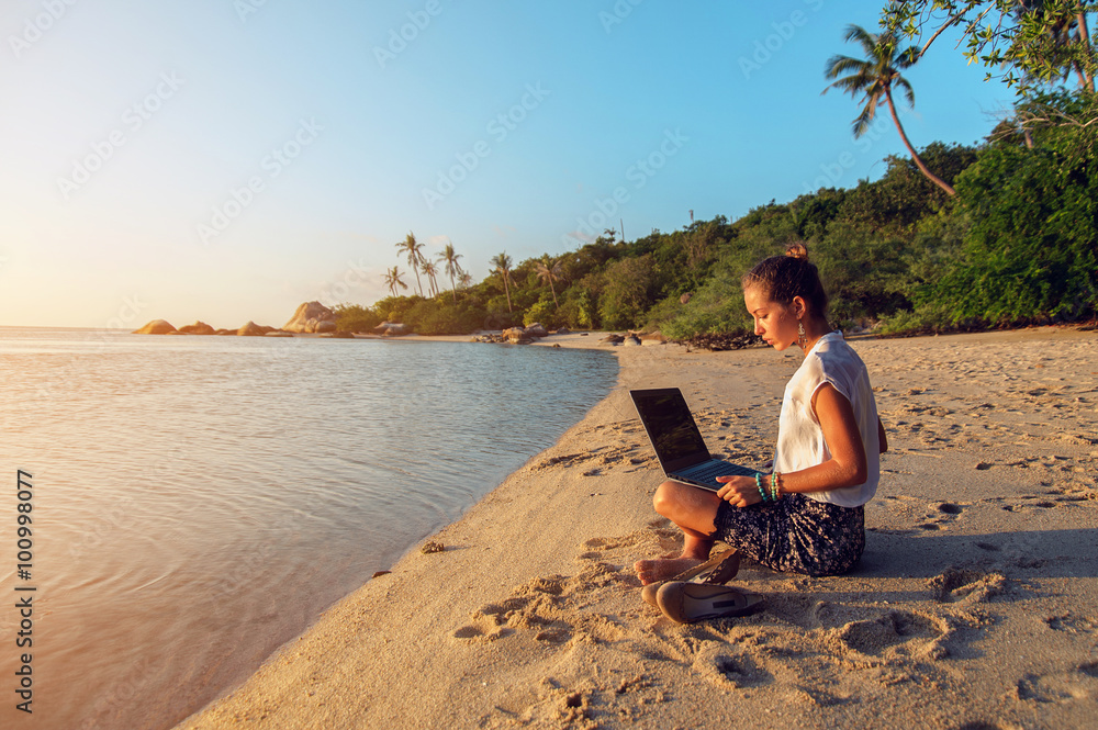 Woman with a laptop on the beach