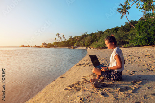 Obraz na płótnie Woman with a laptop on the beach w salonie