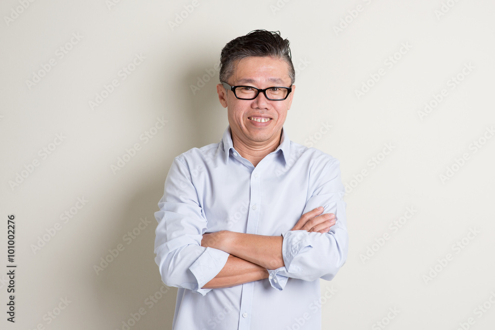 Portrait of mature Asian man arms crossed and smiling Portrait of mature Asian man arms crossed and smiling