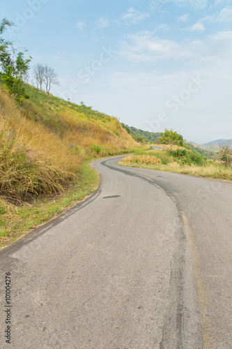 road to moutains with clouds in blue sky