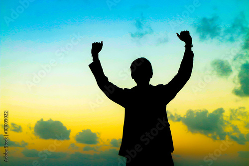 Silhouette of man showing his hand on sunset sky background, Successful business concept.