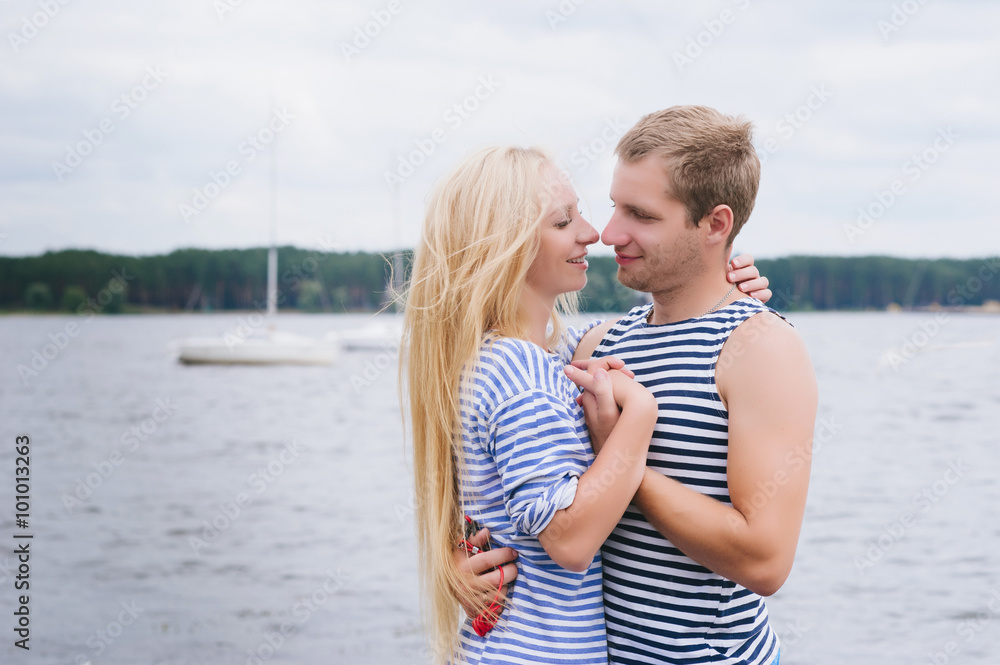 Portrait of a romantic couple in a striped T-shirt hugging and smiling, lifestyle, love, romance, relationships Portrait of a romantic couple in a striped T-shirt hugging and smiling, lifestyle, love, romance, relationships