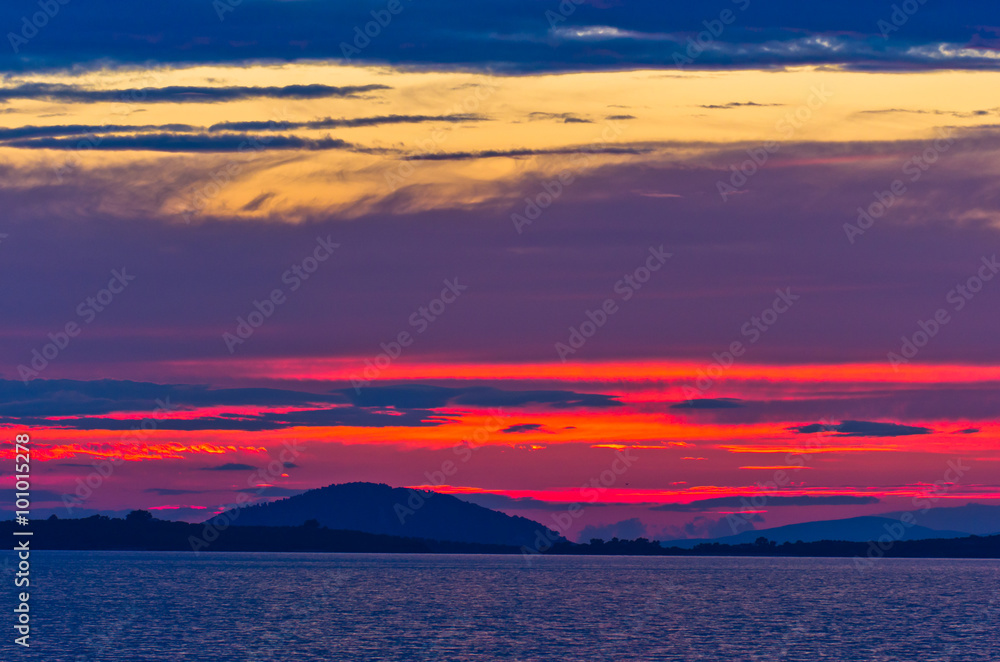 Sunset at sea, with small greek islands in background, Sithonia, Greece