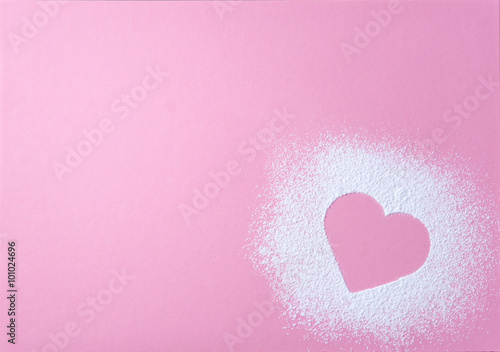 Canvastavla Heart shape made of icing sugar on pink grainy paper surface