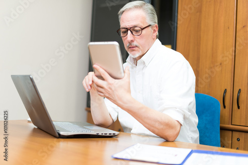 Man using a tablet and a laptop in his studio