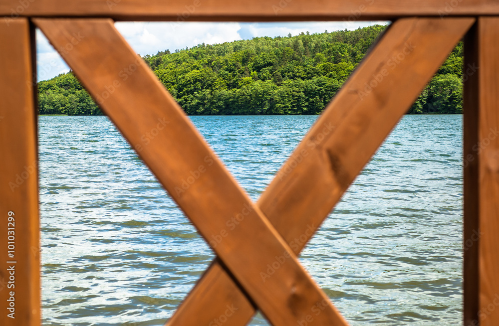Landscape of beautiful lake in the summer. View through a wooden