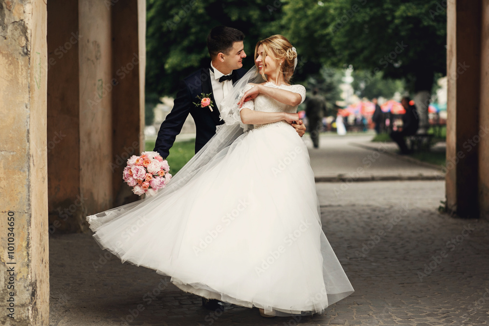 Happy handsome groom and blonde beautiful bride in white dress d