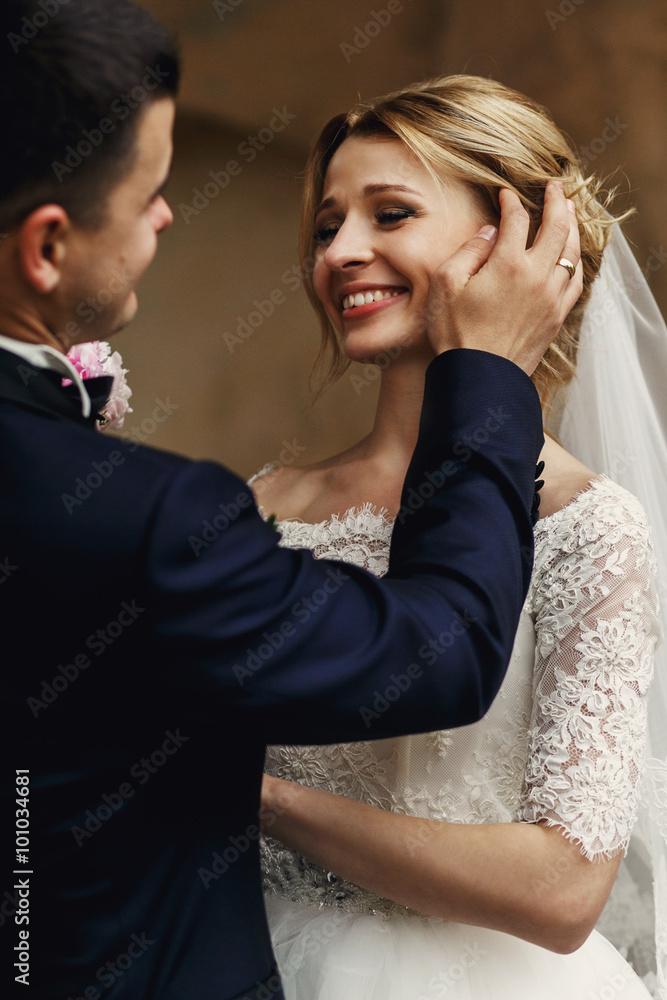 Happy sensual handsome groom and blonde beautiful bride in white Happy sensual handsome groom and blonde beautiful bride in white