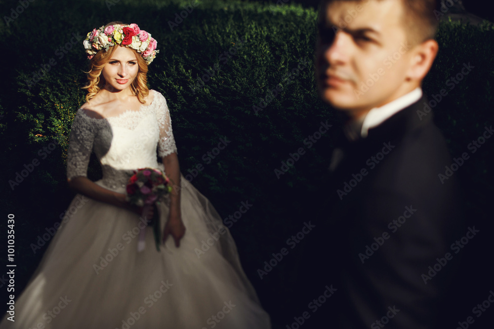 Romantic handsome groom in suit posing with gorgeous young bride