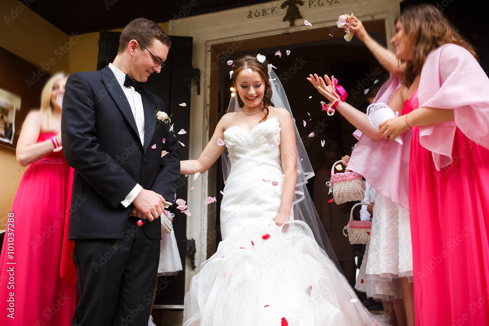 elegant stylish happy groom and bride  under roses petals